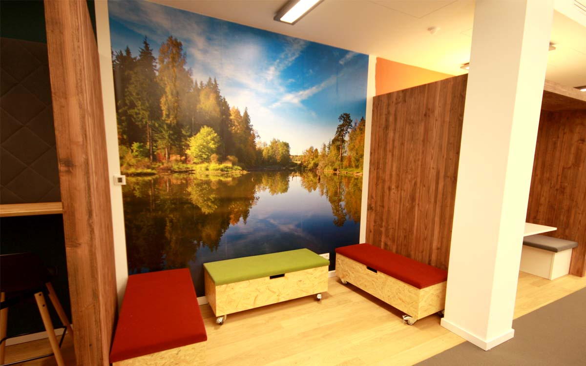 Modernes Arbeitskonzept in einer Agentur für Kommunikation<br />Wände in Altholzoptik, Sitzfläche mit Filzstoff bespannt